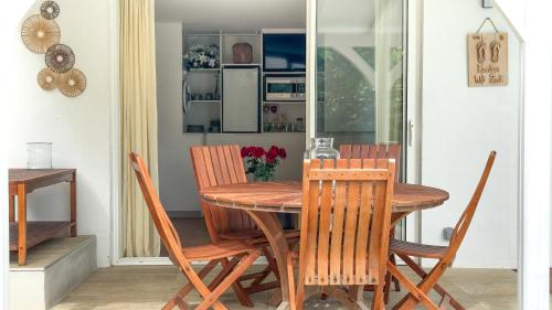 a dining room with a wooden table and chairs at Lagon privé du Diamant in Le Diamant