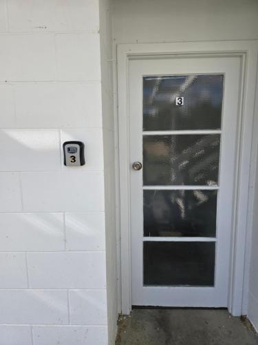 a door with a speed limit sign next to it at Twinkle Orchard Camp in Taupaki