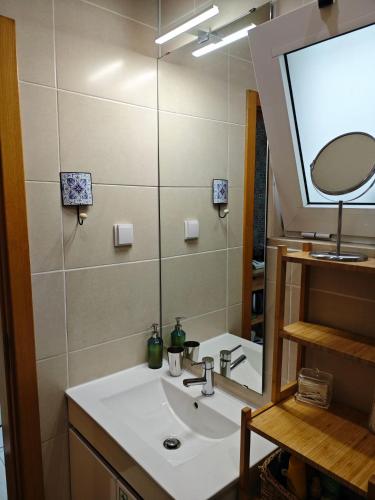 a bathroom with a sink and a mirror at The Sunny Cottage by Freetimealgarve in Faro