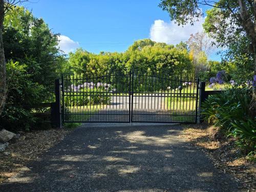 a gate at the entrance to a garden at Twinkle Orchard Camp in Taupaki