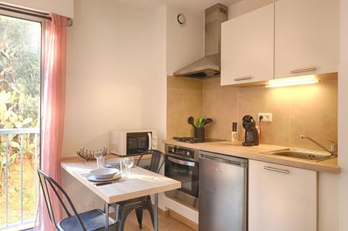 - une petite cuisine avec une table et un comptoir dans l'établissement Beau studio Routes des Sanguinaires proche de la plage, à Ajaccio
