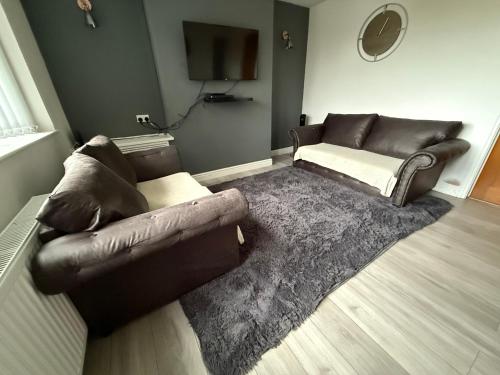 a living room with a leather couch and a rug at Cosy, Modern Home Near BHX, NEC and City Centre in Birmingham