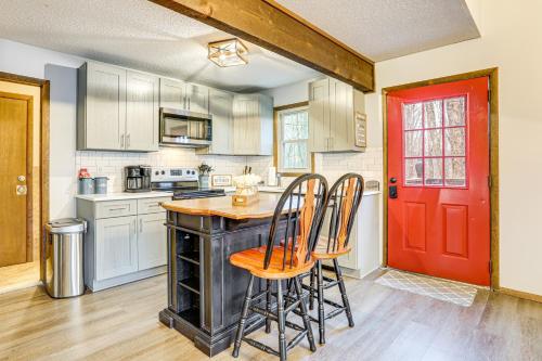 a kitchen with a red door and some chairs at Walk to Roaming Woods Lake Home with Fire Pit! in Hamlin