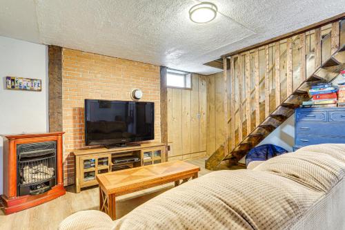 a living room with a television and a staircase at Walk to Roaming Woods Lake Home with Fire Pit! in Hamlin