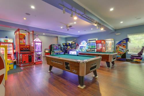 a game room with two pool tables and arcade machines at Walk to Roaming Woods Lake Home with Fire Pit! in Hamlin