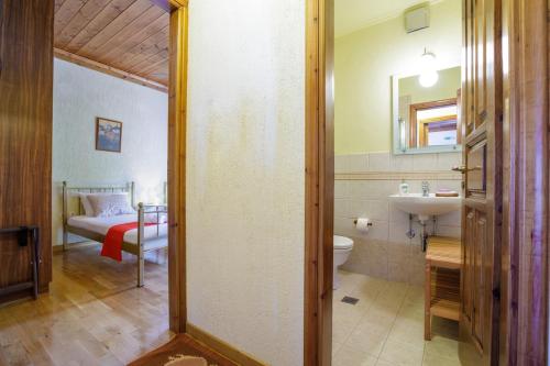 a bathroom with a sink and a toilet and a bed at Holiday house Elliniko Arcadia in Elliniko