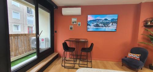 une pièce avec une table, des chaises et une fenêtre dans l'établissement Studio climatisé Place de Jaude Garage balcon tv wifi, à Clermont-Ferrand