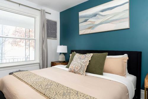 una camera da letto con un letto con pareti blu e una finestra di Private 2 Storey Home with 3BR-2BA by Queen West a Toronto
