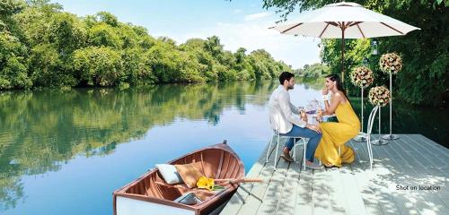 プネにあるLuxe Boho Vibes Lodha Belmondo Pune with Golf Courseの船のテーブルに座る男女