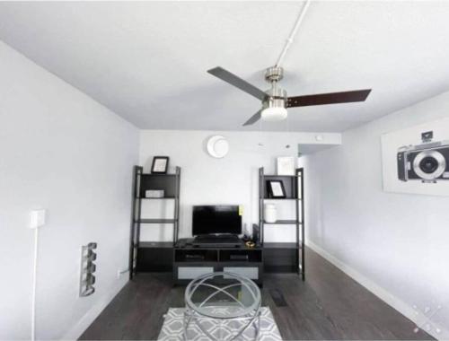 a living room with a ceiling fan and a desk at Nifty Trailer With Spacious Parking in Visalia