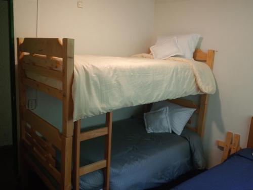 a bedroom with two bunk beds and a blue bed at La Juana Posada en Tenjo in Tenjo