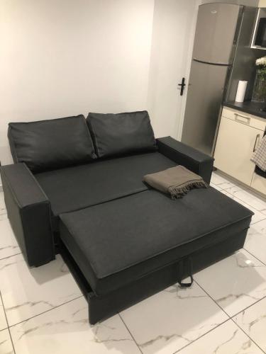 a black couch sitting in a living room at Cozy and well located apartment in Tremblay En France