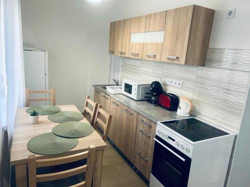 a kitchen with a table with chairs and a stove at Belvárosi Apartman in Zalaegerszeg