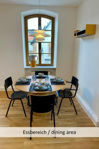 a dining room table with chairs and a window at Neue90 - Fewo Saumagen, Weinstraße Kallstadt Pfalz in Kallstadt