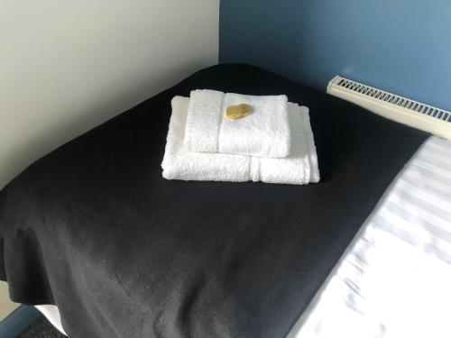 a bed with two white towels on a table at Bassett Home - Single Room And Free Parking in Southampton