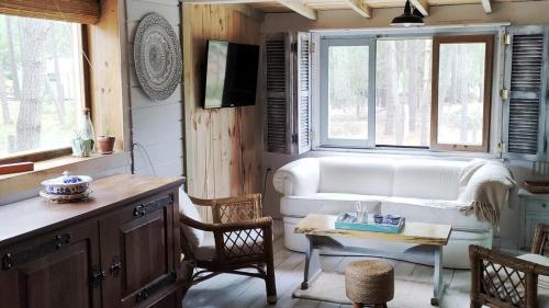 a living room with a white couch and a table at Hermosa Cabaña a 400mt del mar in Rocha