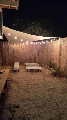 a patio with a bench and lights on a wall at Hermosa Cabaña a 400mt del mar in Rocha