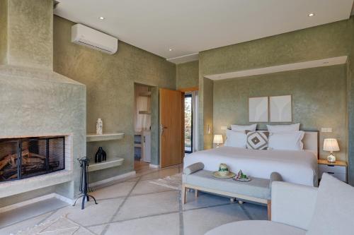 a bedroom with a bed and a fireplace at Les Roses By La Siredrah in Marrakech