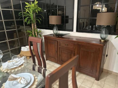 ein Esszimmer mit einem Tisch und zwei Lampen in der Unterkunft Villa Paz in La Romana