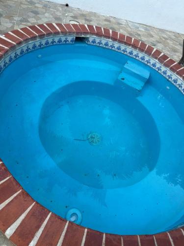 ein großes blaues Schwimmbecken mit einer Ziegelsteinumrandung in der Unterkunft Villa Paz in La Romana