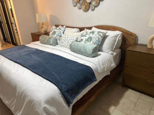 ein Bett mit einer blauen Decke und Kissen darauf in der Unterkunft Villa Paz in La Romana