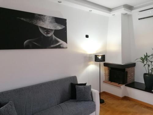a living room with a couch and a picture of a woman at Il Melangolo in Tivoli