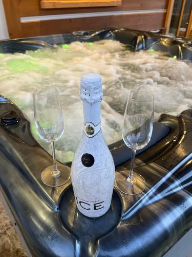 a bottle of champagne and two wine glasses in a hot tub at Roubenka Vanedi in Olešnice v Orlických horách