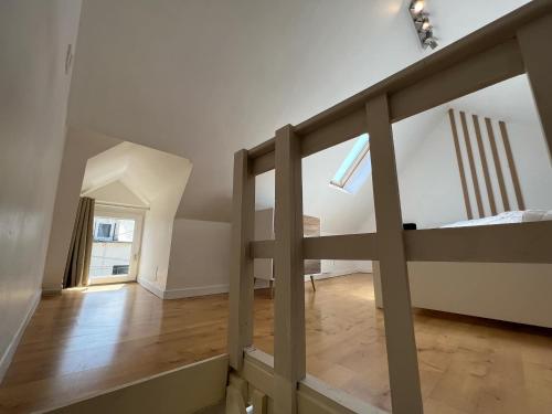 a room with a staircase and a bed in it at Cosy Duplex ! Situation centrale - proche plage et commerces - linge de lit et serviettes de toilette compris in Ouistreham