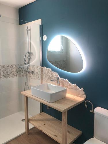 une salle de bain avec un lavabo blanc et un miroir dans l'établissement Les Louisettes, à Grand-Village-Plage