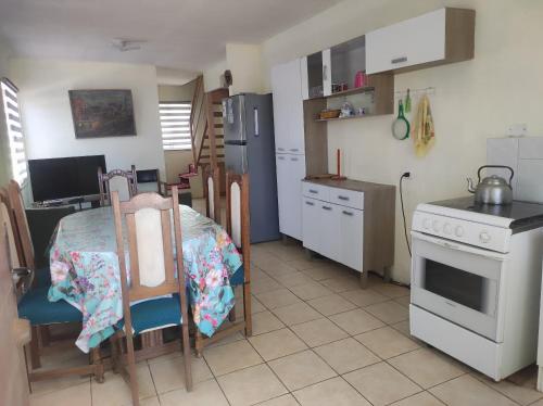 una cocina con mesa y una cocina con estufa en Alojamiento Miguel y Lily, en El Tabo