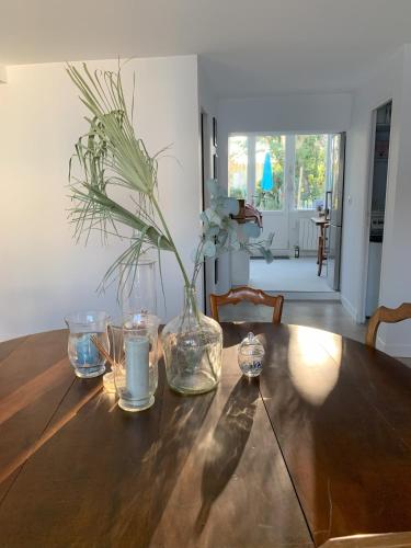 une table en bois avec un vase et des fleurs. dans l'établissement Les Louisettes, à Grand-Village-Plage
