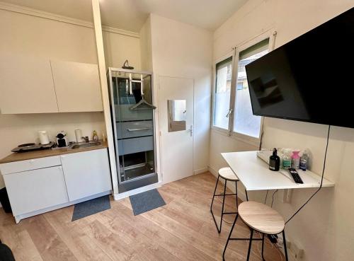 une cuisine avec un comptoir et une table avec des chaises dans l'établissement Jolie chambre équipée proche vélodrome mer, à Marseille