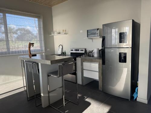 MarbellaにあるHorizon Suite at Solindo Staysのキッチン(ステンレス製の冷蔵庫、シンク付)