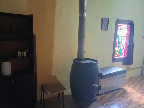 a kitchen with a stove in the corner of a room at Ñanderoga in San Marcos Sierras