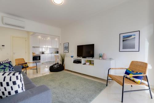 a living room with a couch and a tv at Charming 3 Bedroom Apartment Close to Historic Center-Lagos in Lagos