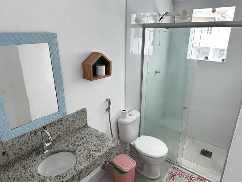 a bathroom with a toilet and a sink and a mirror at Casa na Frente da Praia do Maçarico in Salinópolis