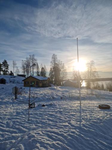 a snow covered field with the sun in the background at Säbytorp in Kil