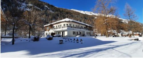 a white building in the snow with a mountain at Aquarell Apartments in Saas-Grund