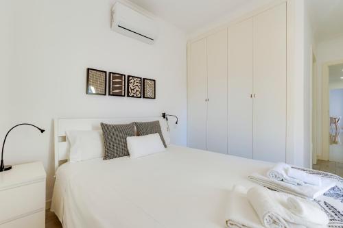 a white bedroom with a white bed and a mirror at Charming 3 Bedroom Apartment Close to Historic Center-Lagos in Lagos