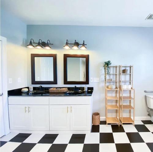 a bathroom with two sinks and a checkered floor at Sojourn The Lighthouse Beach Front Resort Villa in North Camellia Acres