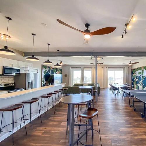 a restaurant with tables and chairs and a ceiling fan at Sojourn The Lighthouse Beach Front Resort Villa in North Camellia Acres