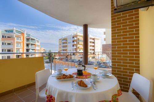 a table with plates of food on a balcony at Charming 3 Bedroom Apartment Close to Historic Center-Lagos in Lagos