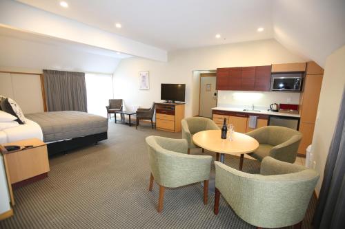 a hotel room with a bed and a table and chairs at Dunedin Leisure Lodge - Distinction in Dunedin