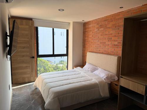 a bedroom with a large bed and a brick wall at Torre Luum by Duna Stays in Guadalajara