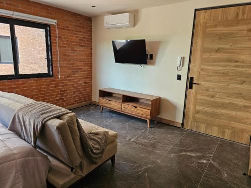 a bedroom with a bed and a tv on a wall at Torre Luum by Duna Stays in Guadalajara