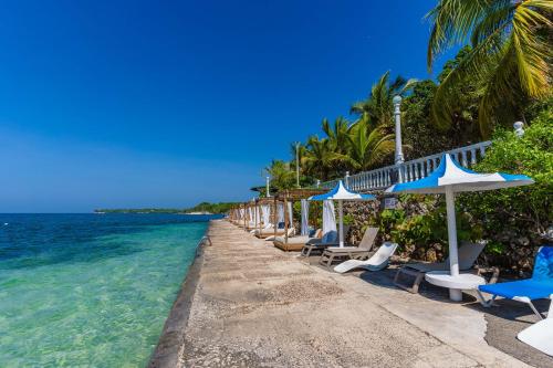 a row of chairs and umbrellas on a beach at Hotel Cocoliso Island Resort in Isla Grande