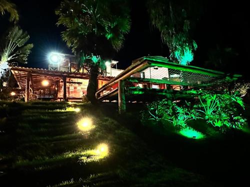 a wooden bridge at night with green lights at Rancho Recanto da Serra in Delfinópolis