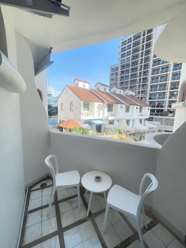 Un balcón con dos sillas y una mesa. en Studio 24 sqm near beach monthly rent, en Pattaya South