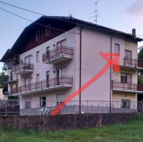 a building with a red cross painted on the side of it at Piccolo appartamento in montagna in Serina