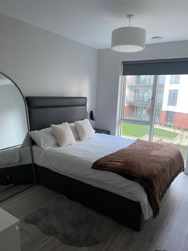 a bedroom with a large bed with a large window at Cozy room in a shared apartment in Lucan